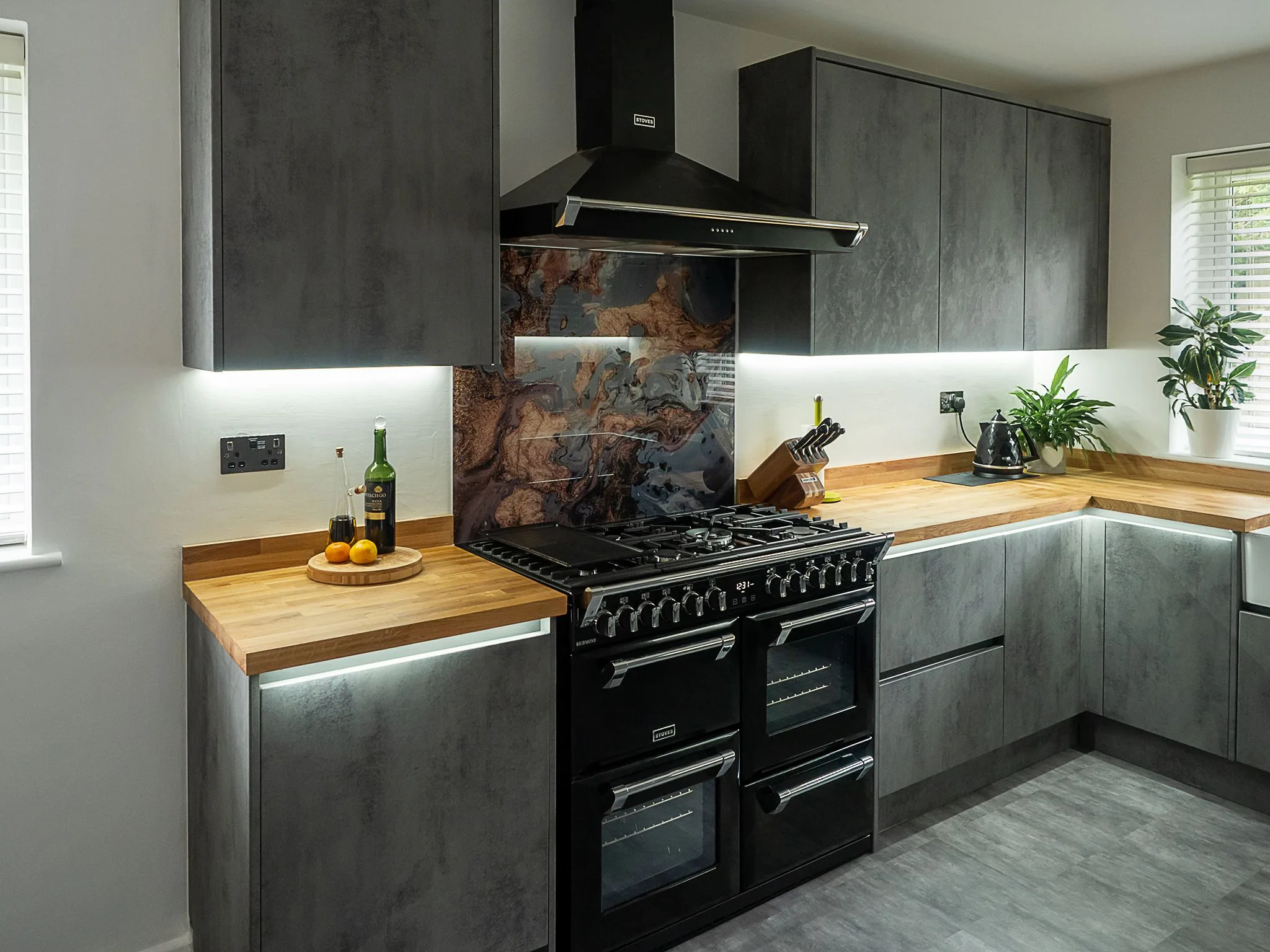 Kitchen fitting — dark grey cabinets with wooden counters and range cooker